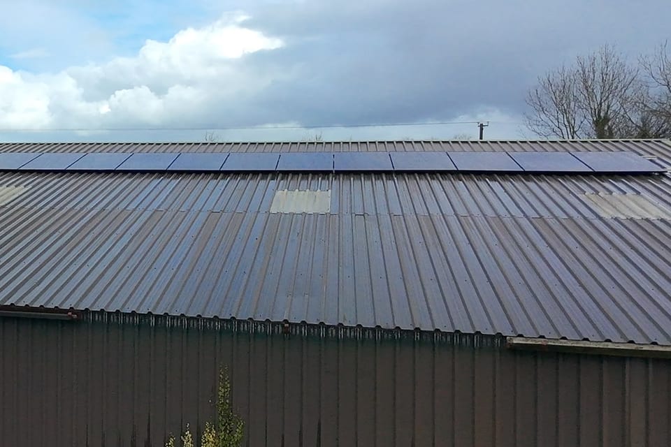 A long run of solar panels along the roof of an agricultural shed